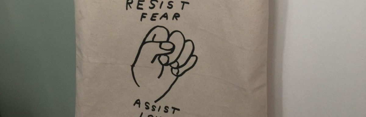 Tote bag reading "resist fear, assist love"